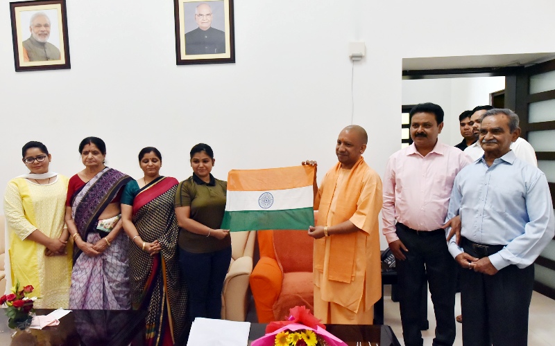 UPCM पर्वतारोही पूर्वा धवन को राष्ट्रीय ध्वज प्रदान करते हुए