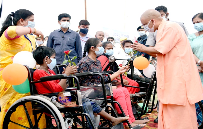 UP CM Yogi: वाराणसी में दिव्यांगजन को कृत्रिम अंग एवं सहायक उपकरण वितरित